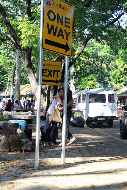 A tender moment softens the utilitarian characteristics of park sstreetshooter - one way to exitgnage. (Quezon Memorial Park, Quezon City)