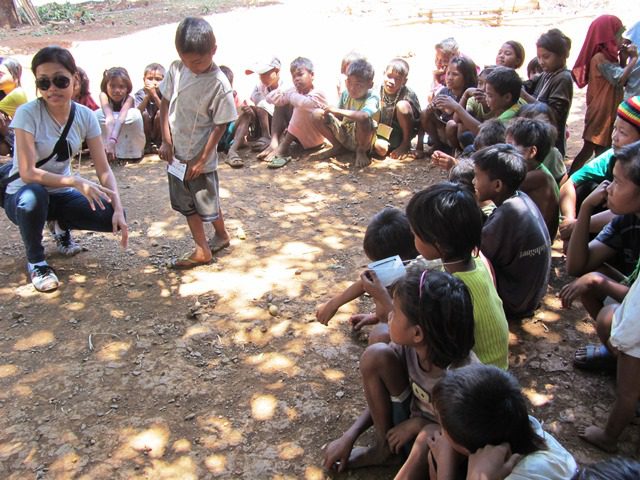 Mangyan children's storytelling under the tree, with IDPIP volunteer (Photo by M. Salamat / Mangyan Day 2013 / www.bulatlat.com)