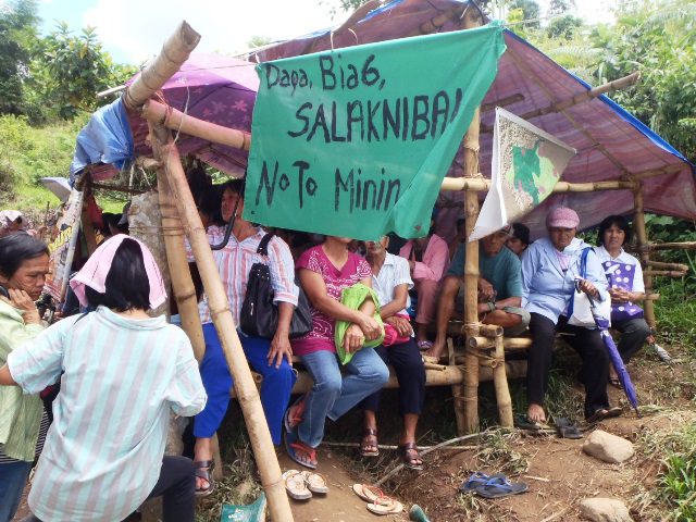 Supporters of anti-mining barricade in Dupax del Norte seek shelter at a makeshift hut . Streamer says, Protect the Land, Life. No to Mining! (Photo courtesy of farmers/scientists for organic farming, MASIPAG-NV)