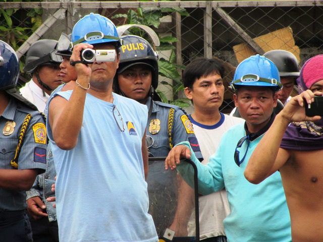 At Pentagon gate after truck and stone-throwing incident, policemen, Pentagon security guards and 'scabs' stand facing the wounded workers' picketline Jul 13