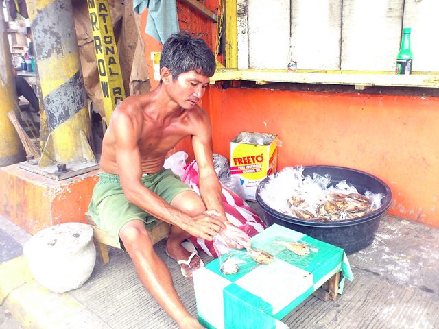 Butch Arcon goes to Manila to sell dried fish because there is no livelihood in relocation site. (Photo by J. Ellao / Bulatlat.com)