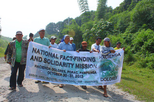 Members of the fact-finding mission and Aniban farmers attempt to go to the farms but are prevented by the security guards of the LLL Holdings Inc. (Photo by Ronalyn V. Olea/ Bulatlat.com)