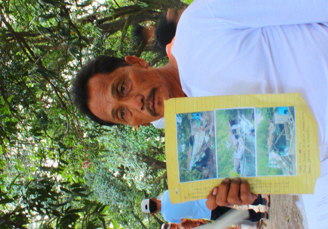 Hector Angeles shows photographs of his hut and pig pen destroyed by the security guards of the LLL Holdings Inc. during a fact-finding mission October 30. (Photo by Ronalyn V. Olea/ Bulatlat.com)