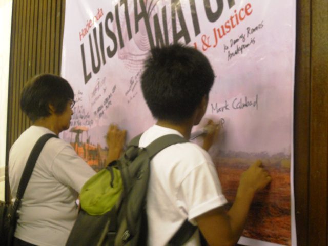 Supporters signing their names in Luisita Watch tarpaulin in solidarity to the Hacienda Luisita farm workers' struggle. (Photo by Anne Marxze D. Umil / Bulatlat.com)