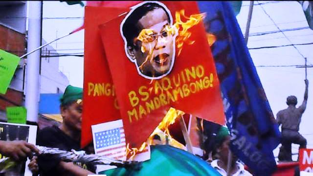 Pictures of Pres. Aquino and other government officials behind 'sellout' of PH resources are burned during protests marking 19th anniversary of Mining Act of 1995. (Photo by Mon Ramirez)
