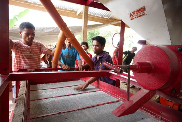 From right: Datu Aldo Talagmame (in navy blue shirt) and Juan kulot (in red shirt), operator of Manobo rice and corn mill, tell mission delegates the state troops inserted shards of glass to clog various parts of the mill's machine, and they took away machine tools. (Photo by BOY BAGWIS / Bulatlat.com)