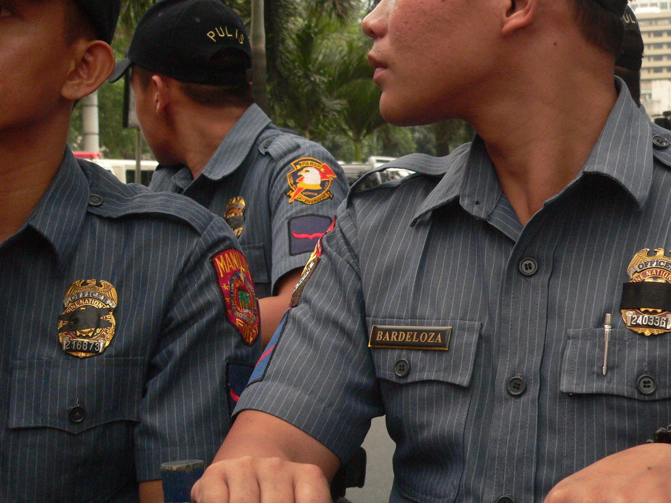 Anti-riot police men wear black ribbon over their badges (Photo by D.Ayroso)