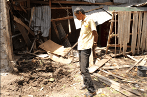 Alon Maytula looks at the crater and his wrecked home pounded by mortar shells. (Photo by Kilab Multimedia)