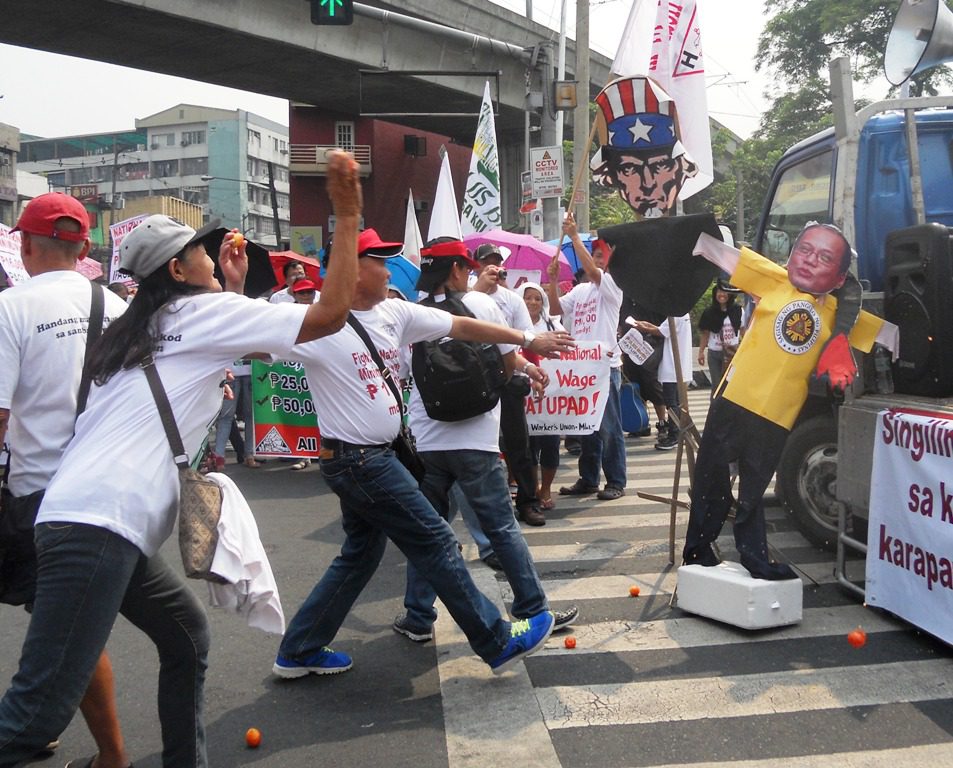 Health workers show their rage by throwing tomatoes at the effigies of President Aquino and the Uncle Sam for implementing anti-people policies like privatization. (Photo by A. Umil/ Bulatlat.com)