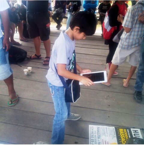 Andoy taking picture of the Hacienda Luisita poster during the Hacienda Luisita massacre anniversary. He said Andoy is also among the "digital natives," he has his own Instagram account. But even then, Crisostomo sees to it that Andoy do other physical activities other than being busy with the social media. (Photo from Vencer Crisostomo's Instagram account/ Bulatlat.com)