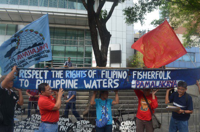Anakpawis partylist Rep. Fernando Hicap (second from left) carries a symbolic fishing boat, with other fisher folk leaders, in a protest in front of the Chinese consulate in Makati (Photo by C. Cabanatan/Bulatlat.com)