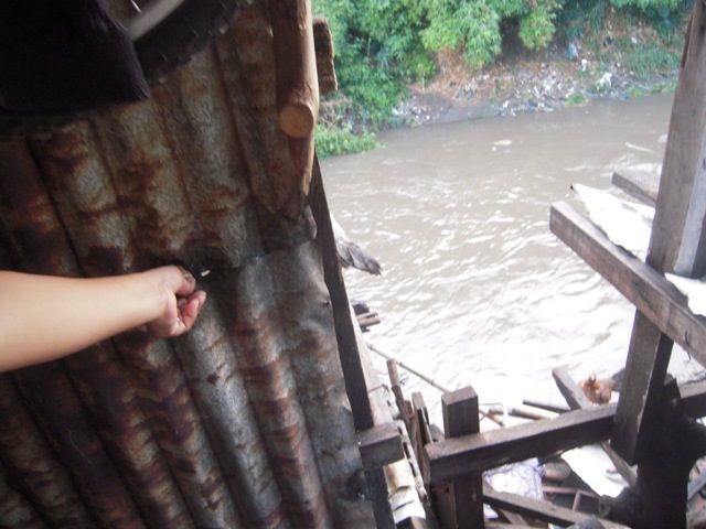 A resident points to how high the floodwaters rise to the second floor of their home during southwest monsoon rains. (Photo courtesy of CTUHR)