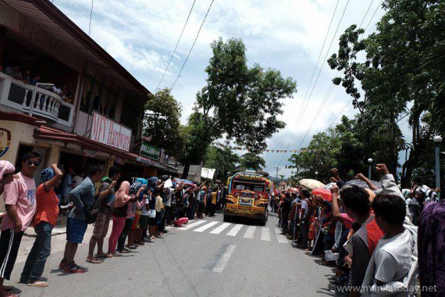 Mourners raised their fists as they lined up at the Lianga town proper (Photo courtesy of Manila Today)