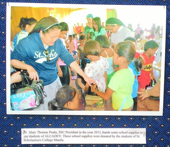 Benedictine sisters distributing school supplies to the students of Alcadev and Trifpps. Photo from the exhibit in St. Scholastica's college.