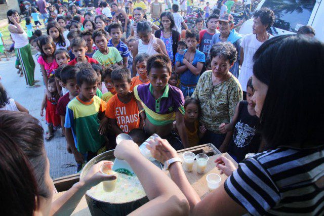 Evacuees line up for porridge prepared by church workers at the Marihatag municipal gym, in Surigao del Sur (Photo by A.Morandante/Davao Today)