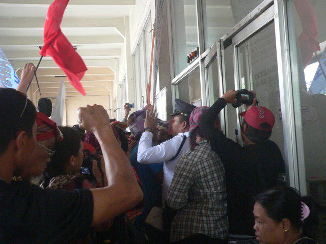 A security guard at the N.Dela Merced building tries to stop the protesters from proceeding to the NCIP office (Photo by D.Ayroso/Bulatlat.com)