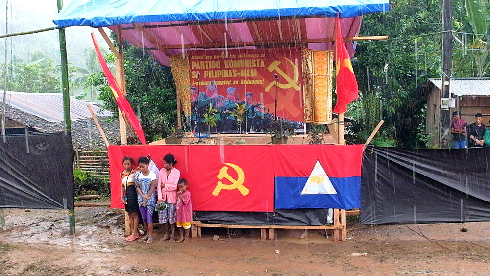 Attendees of the CPP's 47th anniversary celebrations take shelter as heavy rain poured before the program started. (Kitcharao, Agusan del Norte)