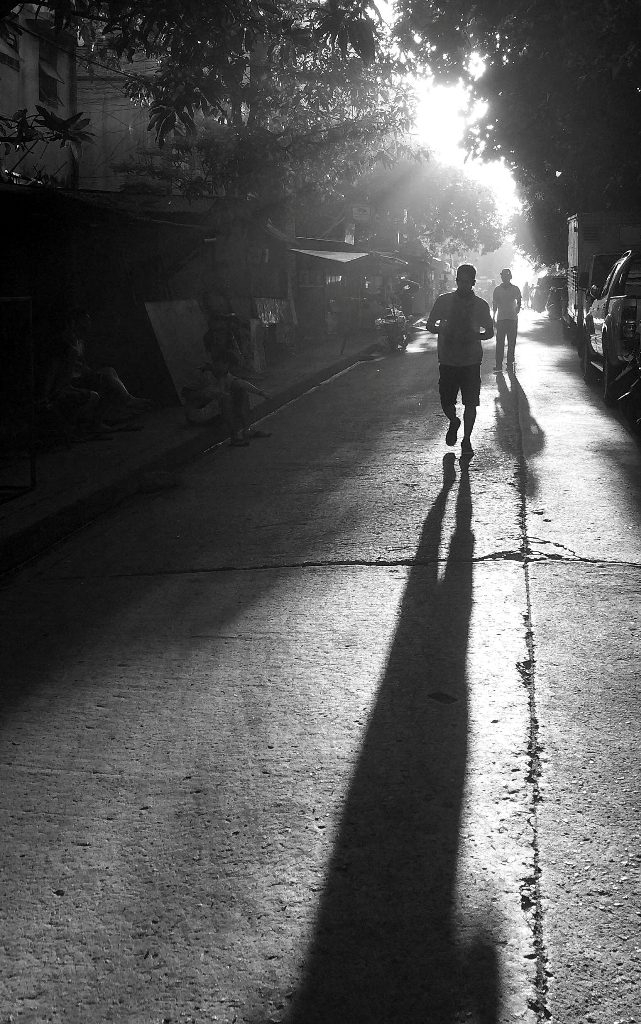 Early morning joggers cast long shadows as the newly-risen sun blesses their exertions. (Commonwealth, Quezon City)