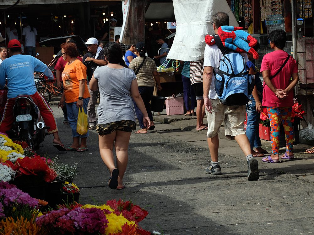 A popular cartoon character seems to be in a quandary as it hangs in an unusual position behind this tourist's back. (Bislig City, Surigao del Sur)