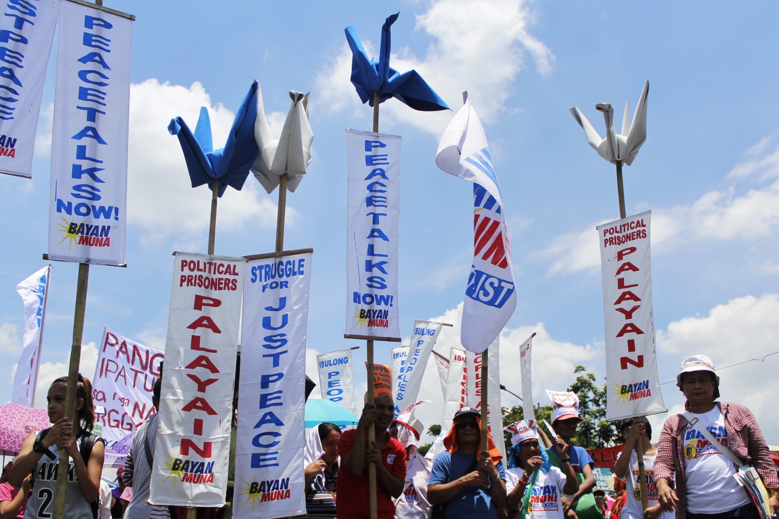 Protesters raise peace cranes as they chant slogans calling for just and lasting peace. (Photo by Karen Ann Macalalad/Bulatlat)