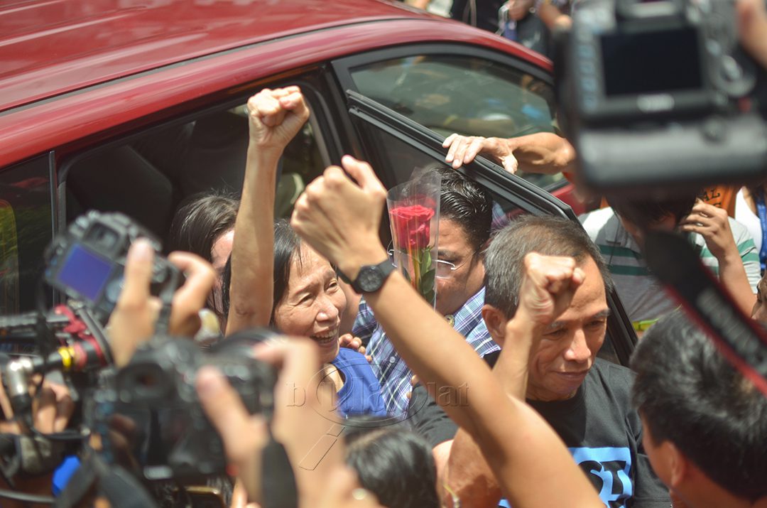 Supporters and members of the media greet Wilma and Benito Tiamzon as they walk out of Camp Crame this morning. (Photo by Loi Manalansan / Bulatlat)