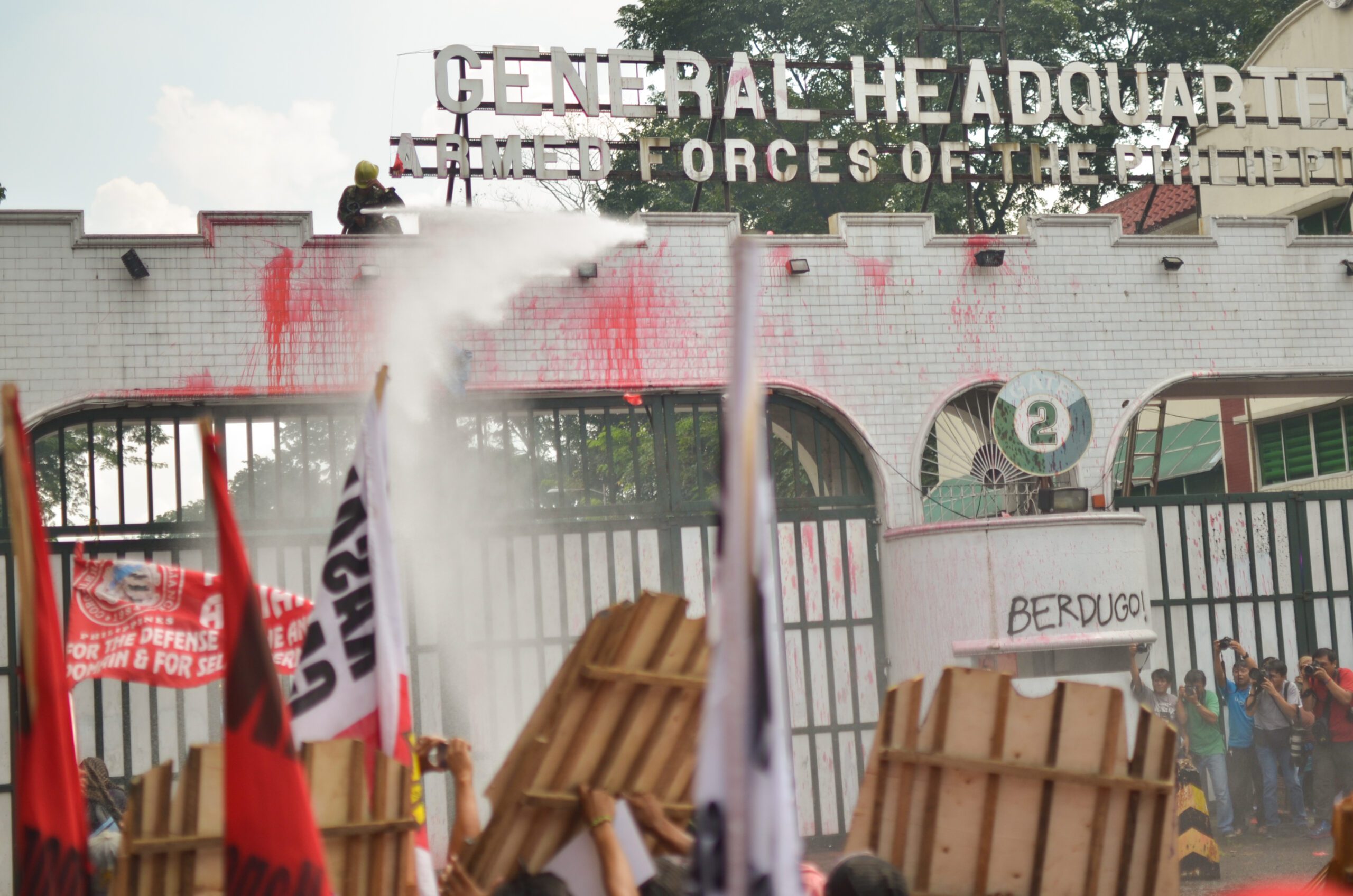 Protesters hurled red paint bombs on Camp Aguinaldo's gates, to depict the killings of activists by suspected soldiers and AFP-backed paramilitary groups. As soon paint smeared the gates, the AFP water cannons opened fired.(Photo by Carlo Manalansan/Bulatlat)