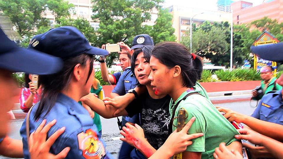 Injured Nicole Soria (in green shirt) being arrested by police women even as her companions were bringing her to the hospital (Photo by Kodao Productions)