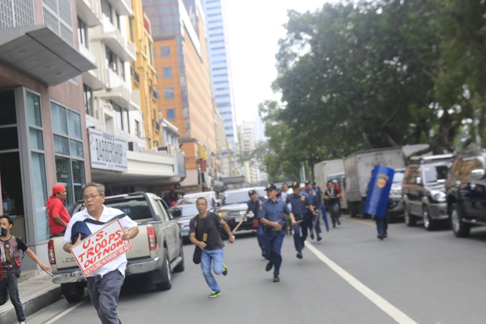 After firing tear gas and ramming a patrol mobile on the protesters, police men chase after those running towards Kalaw avenue, a good distance from the front of US embassy (Photo by Kitanglad Multimedia Collective)