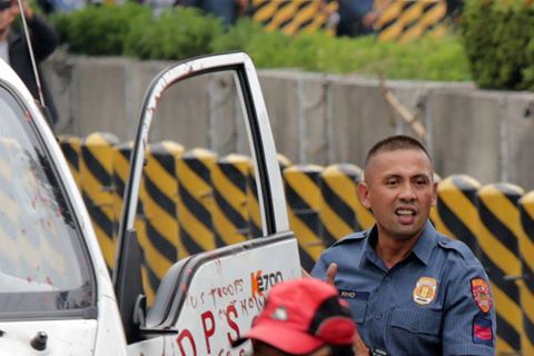 PO3 Franklin Kho, smirking as he got off the police mobile that plowed down and injured 30 protesters. (Photo by Pinoy Weekly)
