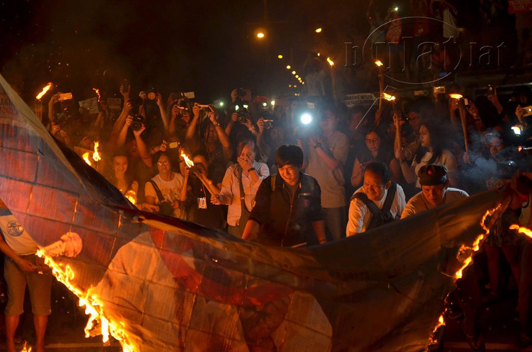 Protesters set on fire a picture of the late dictator Ferdinand Marcos. (Photo by Loi Manalansan / Bulatlat)