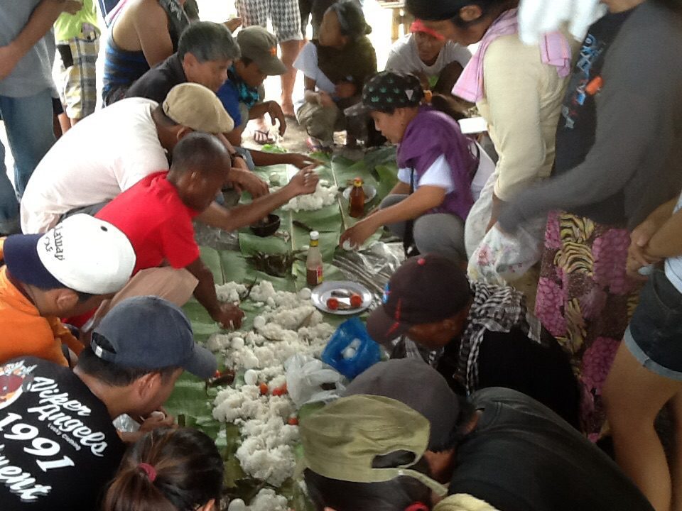 TASTE OF VICTORY. Luisita farmers and supporters share a solidarity lunch, which included eggplants, squash flowers and tomatoes harvested from a bungkalan area. (Photo by Dee Ayroso/Bulatlat)