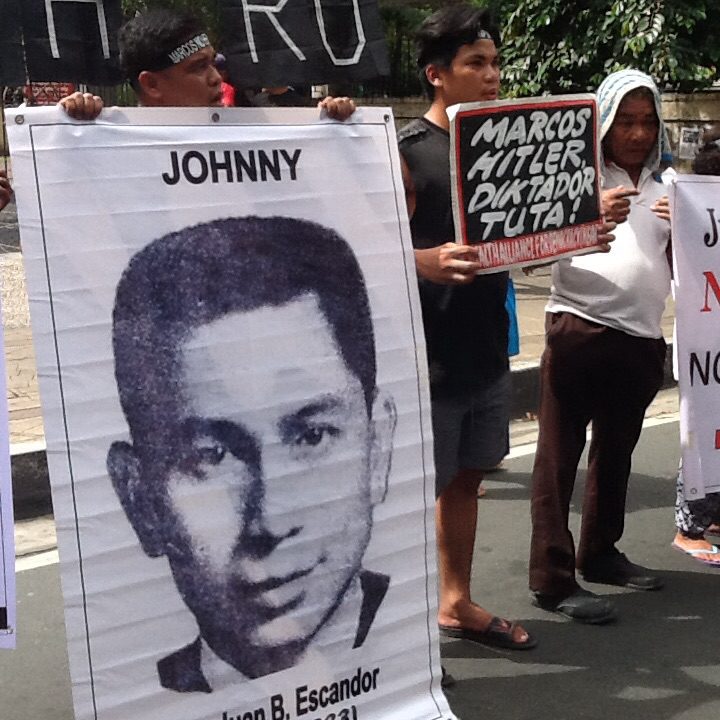 Protesting health workers at UP-PGH carry an image of Dr. Johnny Escandor, who joined the New People's Army and was abducted and killed, his briefs stuffed into his skull during martial law. (Photo by Dee Ayroso/Bulatlat)