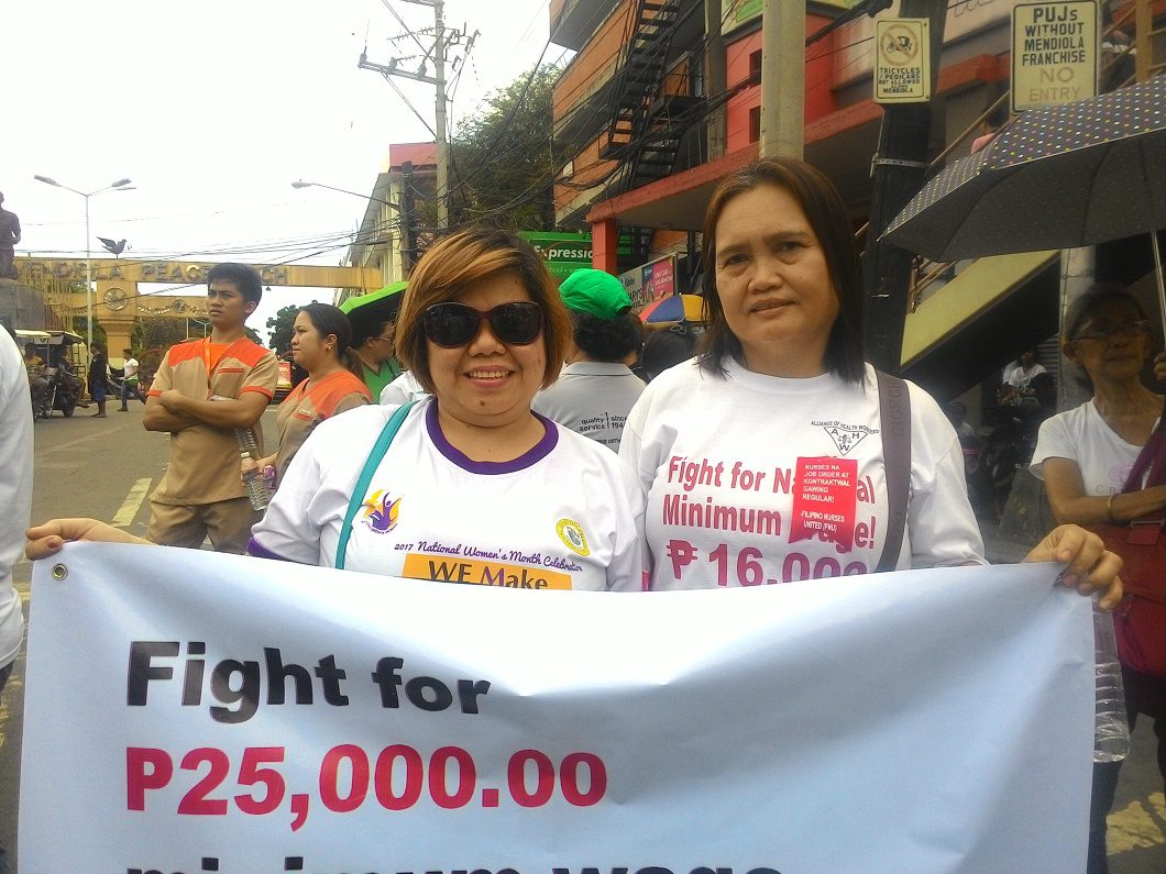 Desiree Reyes (left) and her co-worker in Tondo General Hospital during the commemoration of National Health Workers' Day in Mendiola. (Photo by A. Umil/ Bulatlat)